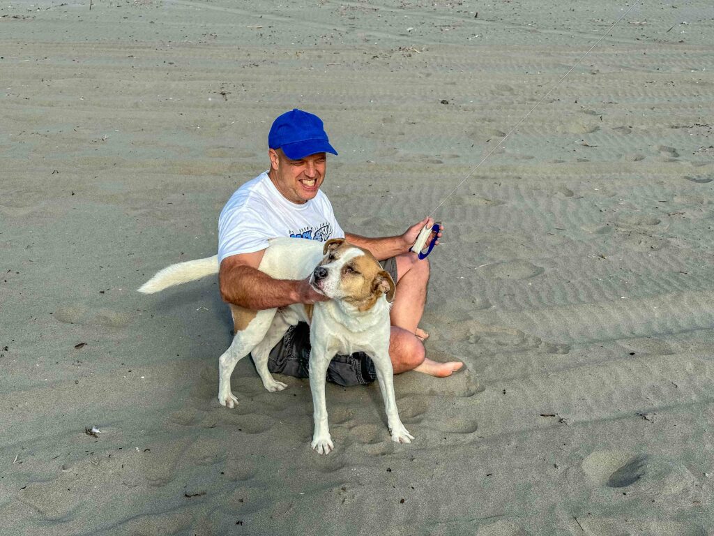 My husband and our dog enjoying beach time at the Coast.