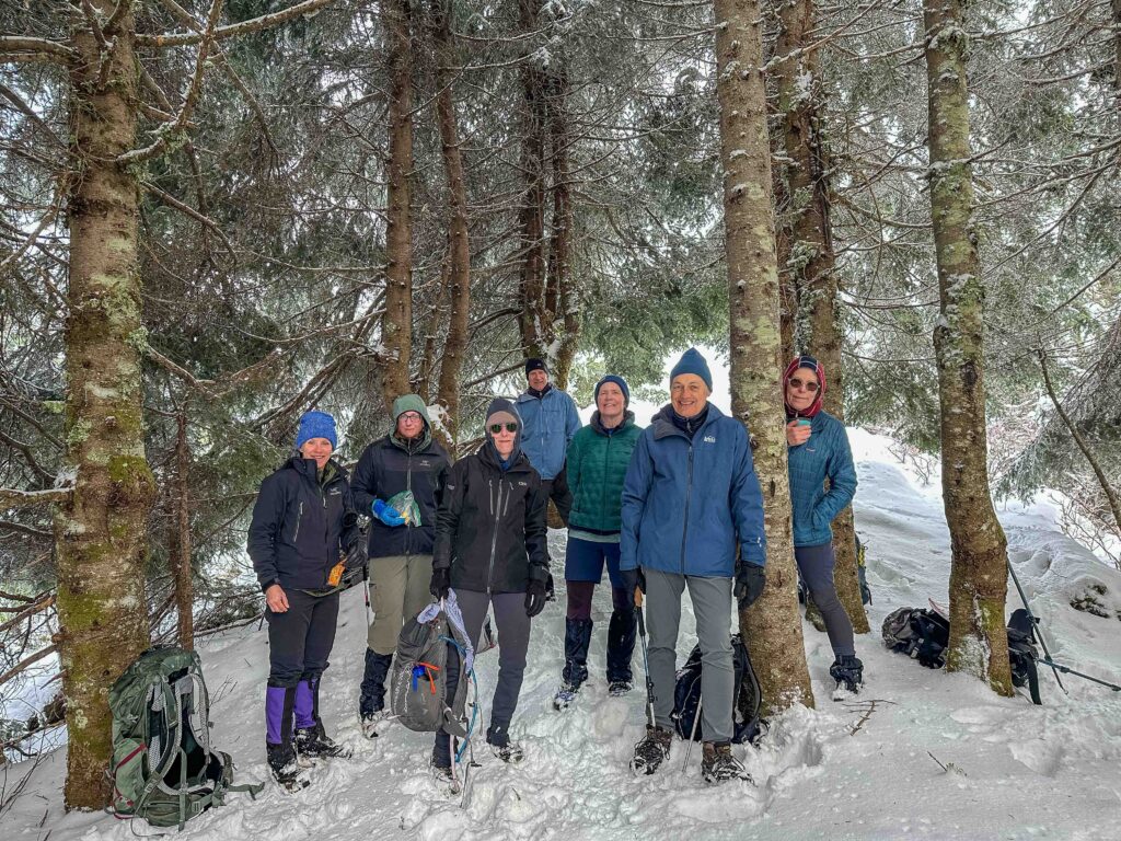 My concept of the summit has expanded to include EVERYONE in the party. Here our group takes a snack/handwarmer break in protection of trees.